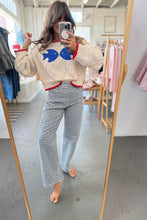 Load image into Gallery viewer, Person taking a mirror selfie wearing a patterned sweater and checkered pants in a clothing store.