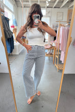 Load image into Gallery viewer, Person wearing a white tank top and checkered pants standing in front of a mirror in a clothing store.
