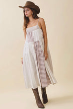 Load image into Gallery viewer, Woman wearing a white dress with striped pattern, brown hat, and boots on a beige background