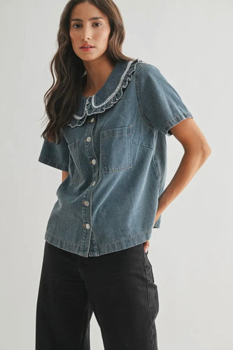 Woman wearing a denim shirt with lace trim on a white background