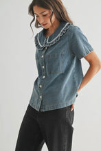 Load image into Gallery viewer, Woman wearing a denim shirt with ruffled collar on a plain background