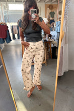 Load image into Gallery viewer, A woman takes a mirror selfie in a clothing boutique, wearing cream-colored pants with a black cat print and a dark gray ribbed top.