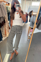 Load image into Gallery viewer, A woman takes a mirror selfie in a clothing boutique, wearing a white ribbed short-sleeve top and black-and-white gingham cropped pants with ruffled hems.