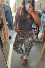 Load image into Gallery viewer, A woman takes a mirror selfie in a clothing boutique, wearing a dark gray ribbed tank top and gray patterned drawstring pants with orange and blue floral accents.