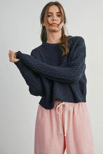 Load image into Gallery viewer, Person wearing a dark blue cable knit sweater and pink pants on a light gray background