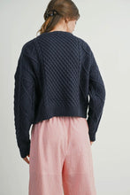 Load image into Gallery viewer, Person wearing a dark blue knitted sweater and pink pants on a light gray background