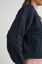 Load image into Gallery viewer, Navy blue cable knit sweater worn by a person on a plain background