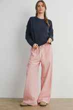 Load image into Gallery viewer, Woman wearing a dark blue knitted sweater and pink wide-leg pants against a plain background
