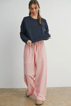 Load image into Gallery viewer, Woman wearing a navy blue knitted sweater and pink checkered pants against a white background