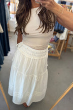 Load image into Gallery viewer, A woman taking a mirror selfie in a clothing store, wearing a cream ribbed tank top and a white tiered midi skirt with a tie waist.