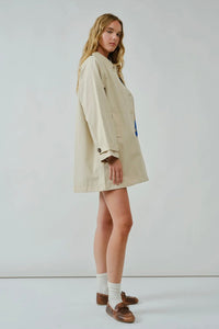 Woman wearing a beige trench coat on a white background