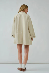 Woman wearing a beige coat against a white background