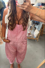 Load image into Gallery viewer, A woman takes a mirror selfie in a clothing store wearing pink corduroy overall-style pants with a white ruffled sleeveless top underneath.