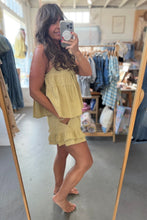 Load image into Gallery viewer, A woman takes a mirror selfie in a clothing boutique wearing a light yellow ruffled sleeveless top and matching mini skirt.