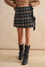 Load image into Gallery viewer, Person wearing a plaid skirt and black boots against a beige background