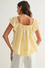 Load image into Gallery viewer, Woman wearing a yellow blouse with ruffled sleeves on a white background