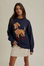 Load image into Gallery viewer, Woman wearing a navy sweater with a dog design on a beige background