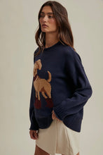 Load image into Gallery viewer, Woman wearing a navy sweater with a dog design on a beige background
