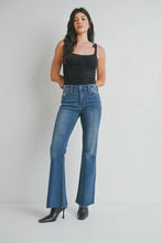 Load image into Gallery viewer, Woman wearing blue jeans and a black top against a plain background