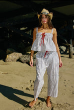 Load image into Gallery viewer, Woman in a striped outfit and cowboy hat on a beach
