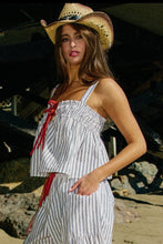 Load image into Gallery viewer, Woman wearing a striped dress and cowboy hat on a beach.