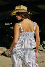 Load image into Gallery viewer, Woman wearing a striped outfit and straw hat on a beach