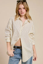 Load image into Gallery viewer, Woman wearing a polka dot shirt and jeans against a beige background