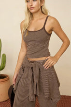 Load image into Gallery viewer, A woman modeling a brown and beige striped crop top and matching striped wrap skirt, standing in a studio setting with a potted cactus in the background.