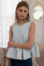 Load image into Gallery viewer, Woman wearing a light blue pleated top in a home setting