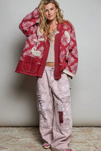 Load image into Gallery viewer, A woman modeling a red and white paisley patterned jacket over a beige crop top, paired with distressed light pink wide-leg cargo pants and pink sneakers, standing against a neutral gray wall.