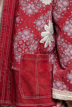 Load image into Gallery viewer, Close-up of a red quilted jacket or robe with white paisley and floral embroidery, contrast stitching, and a large decorative white applique on the front.