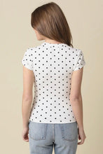 Load image into Gallery viewer, Person wearing a white t-shirt with black polka dots and light blue jeans on a beige background