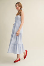Load image into Gallery viewer, Woman wearing a blue striped dress with red shoes on a beige background