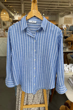 Load image into Gallery viewer, Blue and white striped shirt on a hanger in a store setting
