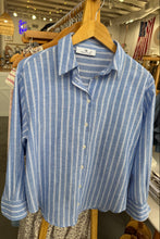 Load image into Gallery viewer, Blue and white striped shirt on a hanger with a store interior background