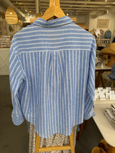 Load image into Gallery viewer, Blue and white striped shirt on a hanger in a store setting