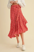 Load image into Gallery viewer, Person wearing a red floral skirt on a beige background