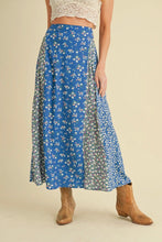 Load image into Gallery viewer, Person wearing a blue floral skirt with a beige background