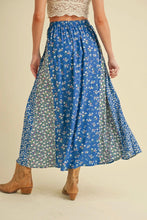 Load image into Gallery viewer, Person wearing a blue floral skirt on a beige background