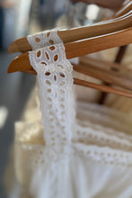 Load image into Gallery viewer, White lace garment on a wooden hanger with a blurred background