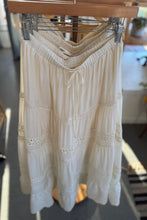 Load image into Gallery viewer, White lace top hanging on a wooden rack indoors