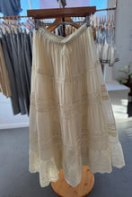 Load image into Gallery viewer, Beige lace skirt on a wooden hanger in a store setting