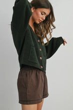 Load image into Gallery viewer, Woman wearing a green cardigan and plaid skirt on a plain background