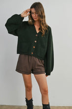 Load image into Gallery viewer, Woman wearing a dark green cardigan over a plaid dress with brown boots on a plain background
