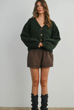 Load image into Gallery viewer, Woman wearing a green cardigan and plaid shorts against a white background