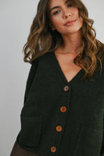 Load image into Gallery viewer, Woman wearing a dark green cardigan with brown buttons on a plain background