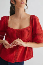 Load image into Gallery viewer, Woman wearing a red blouse with lace details on a plain background