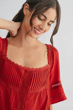Load image into Gallery viewer, Woman wearing a red dress with lace details on a white background