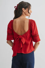 Load image into Gallery viewer, Woman wearing a red blouse with an open back on a white background