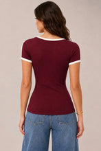 Load image into Gallery viewer, A woman shown from the back wearing a fitted short-sleeve ringer T-shirt in burgundy with white trim on the collar and sleeve cuffs, paired with blue jeans, against a plain light beige studio background.